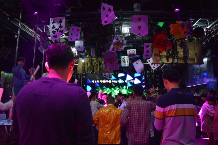 참여자들이 클럽안에서 춤을 추고 있고, 전광판에는 