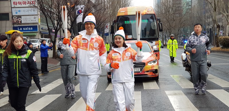 김호식관장님이 성화를 들고 동행주자와 달리는 모습