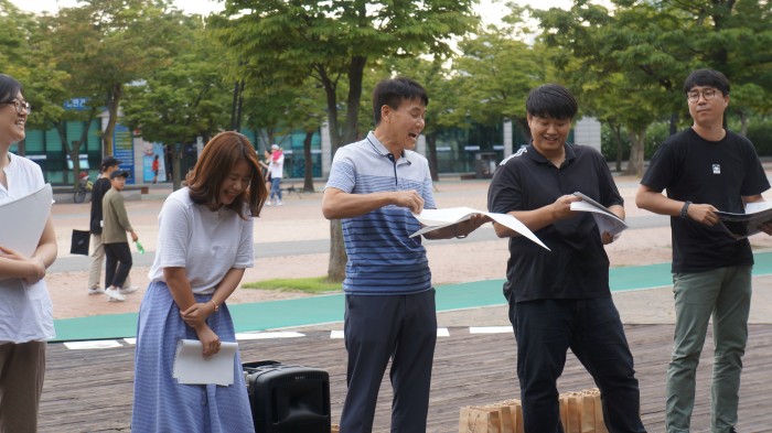 직원들이 무대위에 올라와 스케치북에 직접 작성한 삼행시를 읽고 있는 모습