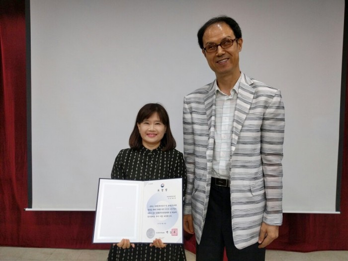 김호식 관장과 민혜경 부장이 표창장을 들고 기념사진을 찍고 있는 모습