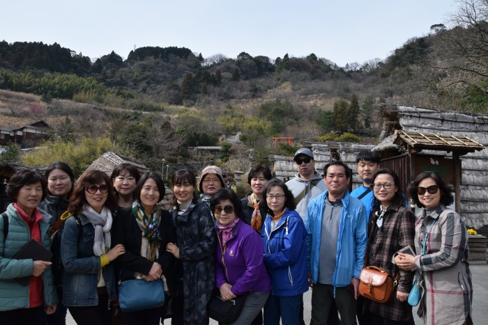후쿠오카 관광지를 배경으로 복지관직원과 활동보조인이 기념사진을 찍고 있는 모습