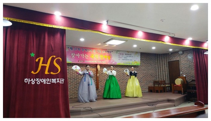 하상복지관 지하 강당 무대에서 판소리 소리꾼 3명이 부채를 들고 춤을 추고 있는 모습