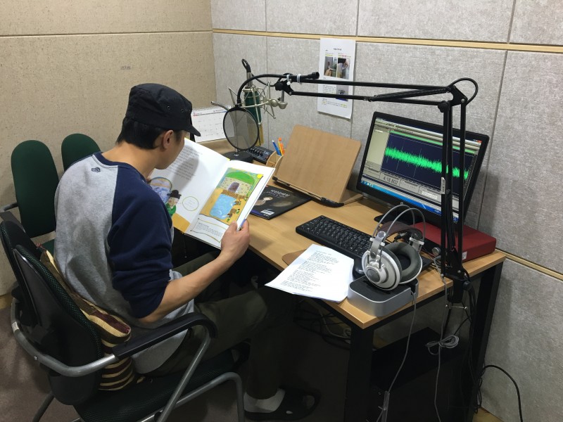 복지관 2층 녹음실에서 프로그램에 참여한 남자분이 책을 녹음하고 있는 모습