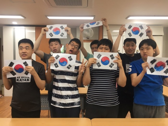 2017년 주간보호 현충일 행사(주간보호실에서 이용자들이 완성한 태극기를 들고 있는 모습)