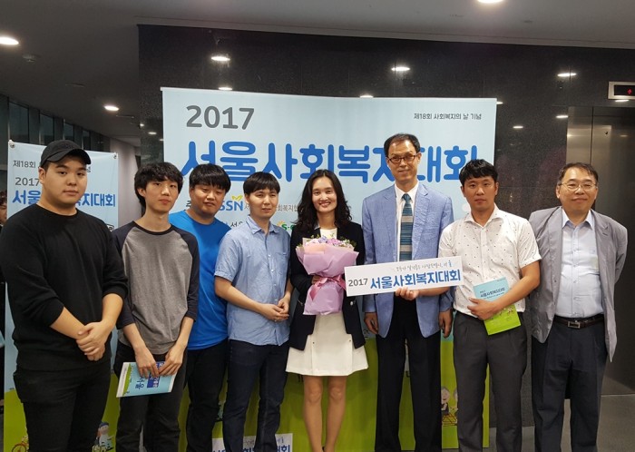 남은숙 부장이 수상 후 꽃다발을 들고 수상장 로비에서 하상장애인복지관 직원들과 기념사진을 찍고 있는 모습