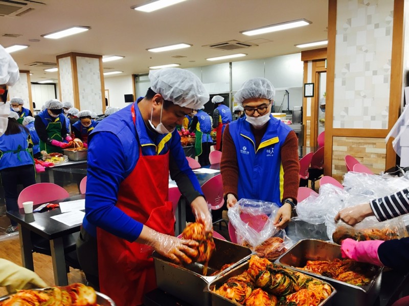 테이블 주변으로 봉사자들이 모여 이웃에게 전달할 김장김치를 버무리고 있는 모습
