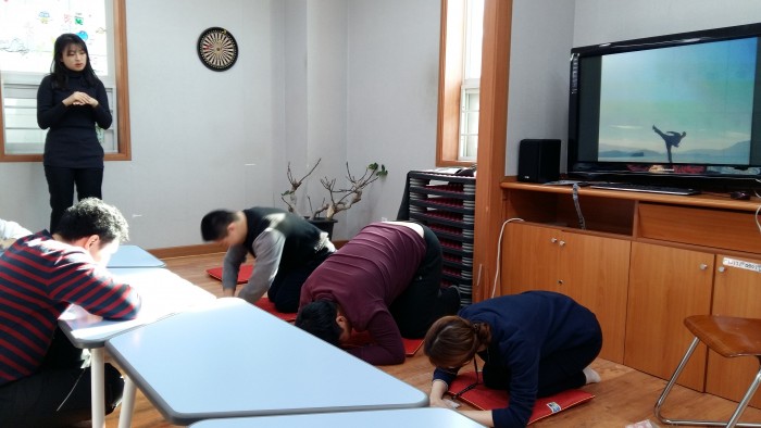 주간보호실에서 이용자들이 바른 자세로 세배드리는 연습을 하는 모습