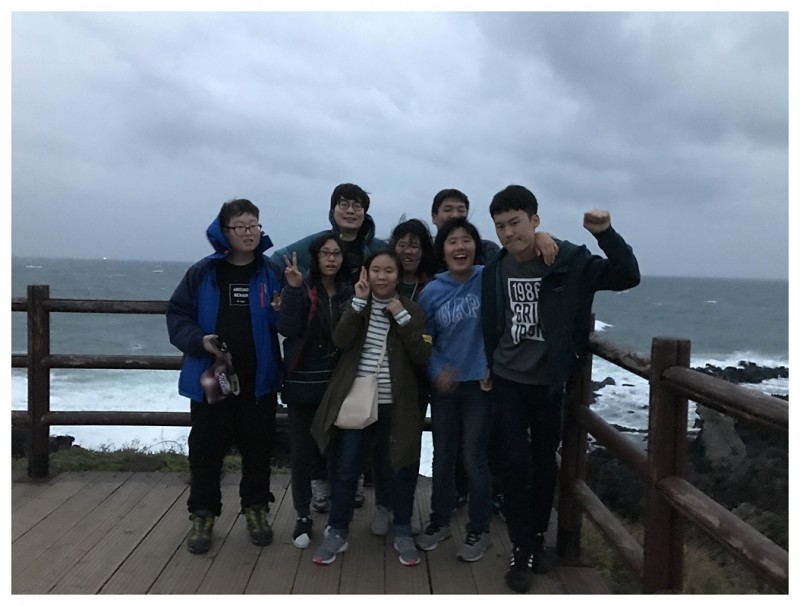 자기결정훈련 프로그램 캠프 참여자들이 제주도 바다를 배경으로 기념사진을 찍고 있는 모습