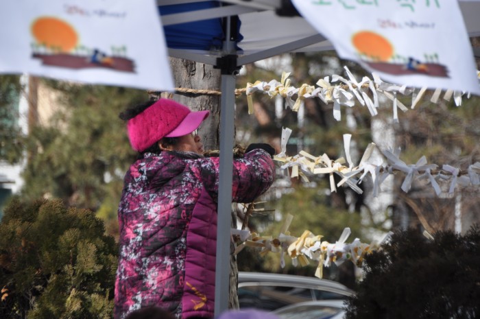 대보름 한마당 행사에서 소원띠를 적은 후 매다는 모습