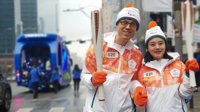 김호식관장님이 성화를 마치고 동행주자와 기념사진을 찍는 모습