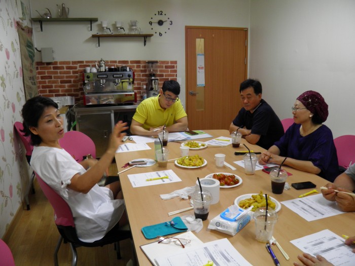 자원봉사위원 분들과 책상에 둘러 앉아 회의를 하는 모습