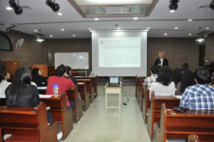 지하 강당에서 문형구 교수님께서 인권경영에 대해 파워포인트를 활용하여 강의하고 계시고, 직원 50여명이 강의를 듣고 있는 모습입니다.