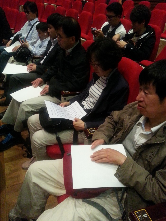 강연 장소에서 강연회 줄거리가 적혀 있는 점자 안내지를 읽고 있는 독서클럽 회원.