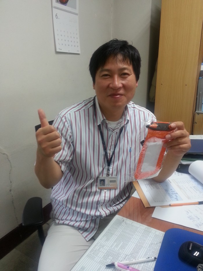 총무팀 김종수 팀장님께서 선물로 스마트폰방수케이스를 들고 포즈를 취하고 있습니다.